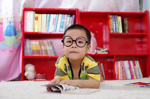 little boy on his stomach reading a book